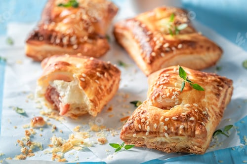 Preview: Hot sausage roll with puff pastry on blue table