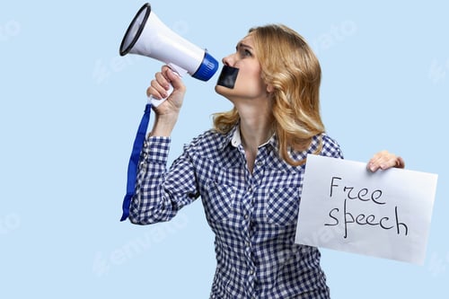 Preview: Blond woman with taped mouth struggling to speak in megaphone.
