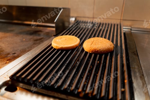 Preview: professional kitchen in hotel restaurant burger buns being grilled close-up