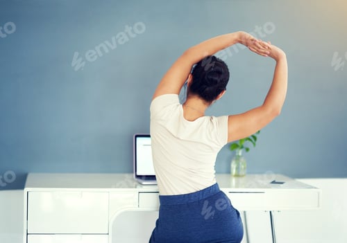 Preview: Time for a refreshing stretch. Cropped shot of a young businesswoman working on her laptop at home.