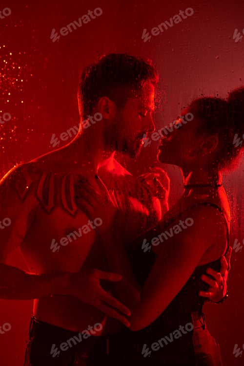 Preview: A passionate embrace between two lovers in a dramatic red lit atmosphere