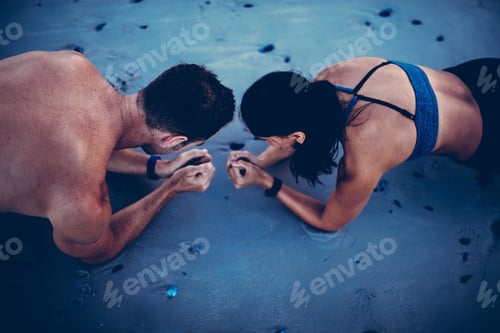 Preview: Couple doing plank exercise on beach together