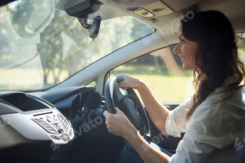 Preview: Smiling woman driving a car