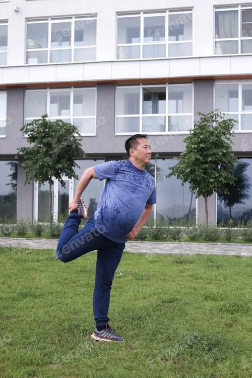Preview: Korean Man Stretches Against The Background Of The City. Healthy Lifestyle. Adult Man Practicing