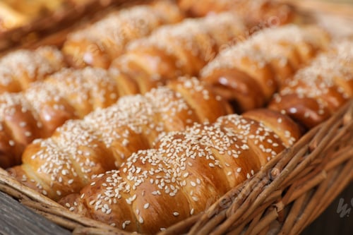 Preview: Wicker tray with tasty fresh buns, closeup. Bakery products