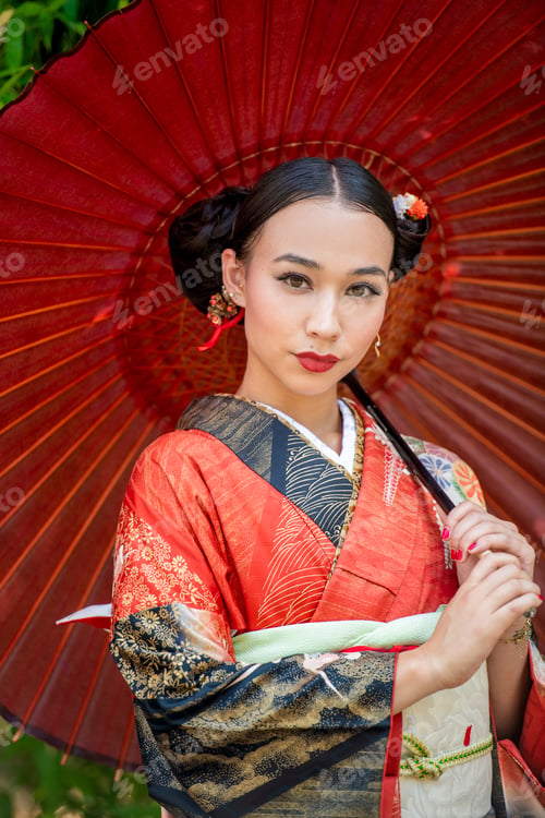 Preview: Elegant woman in traditional kimono with red umbrella