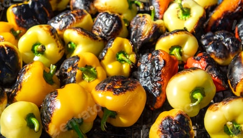 Preview: Man grilling sweet peppers. Selective focus.