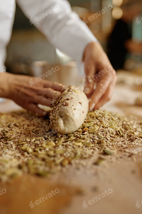 Preview: Baker shaping bread bagels with seeds