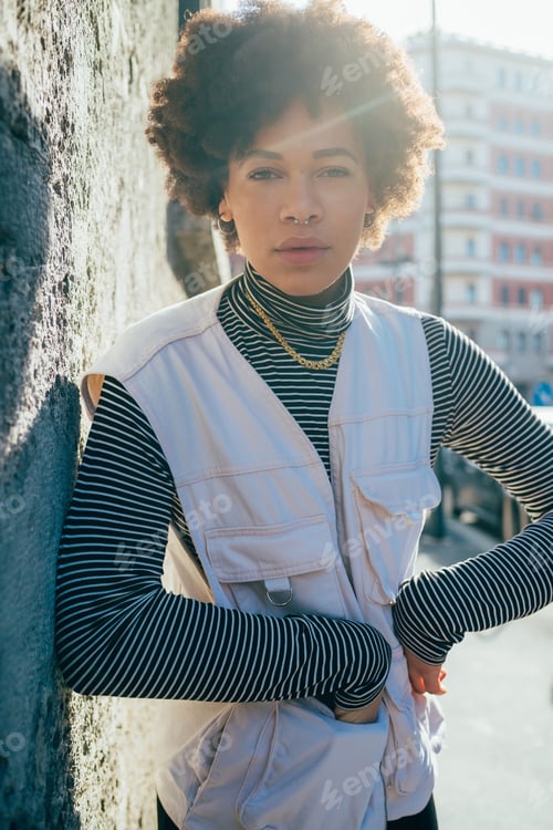 Preview: Fashionable young afro curly hair black woman posing outdoor
