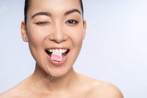 Preview: Smiling Asian woman posing for camera in studio