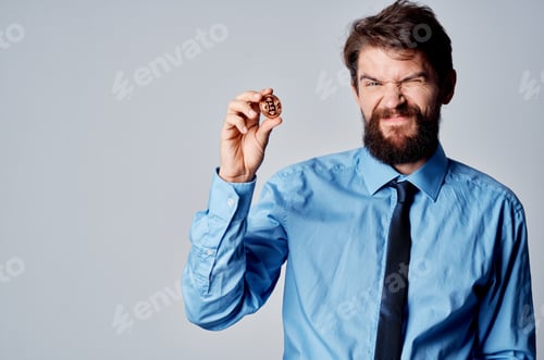 Preview: Aggravated Man Holding Cryptocurrency Bitcoin in Hand