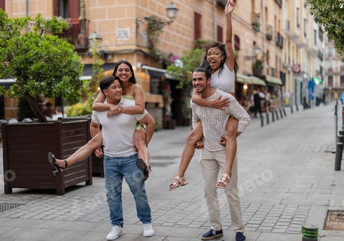 Preview: Young couples enjoying piggyback ride on city street