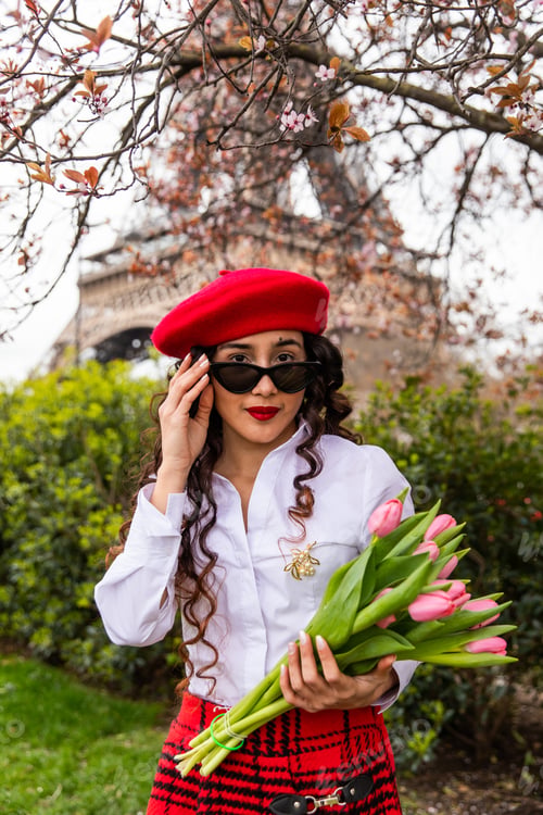 Preview: Portrait of a cute, stylish girl holding pink tulips on the background of Eiffel Tower