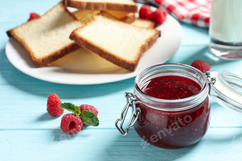 Preview: Sweet raspberry jam and toasts for breakfast on turquoise wooden table