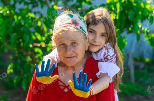 Preview: Child and grandmother hand drawn flag of Ukraine. Selective focus.