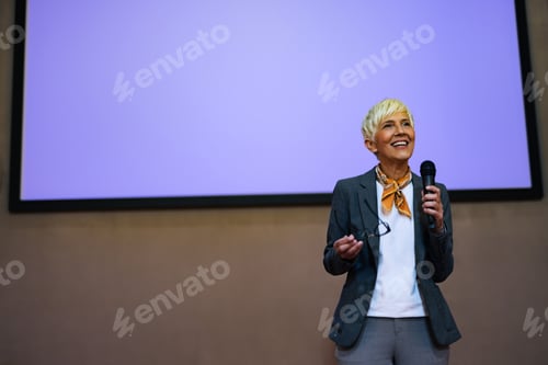 Preview: Woman giving a speech, standing at a projection screen, presenting a business idea.