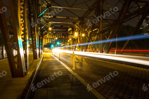 Preview: Long exposure shot of a car with beautiful light trails on a metal bridge in Chicago
