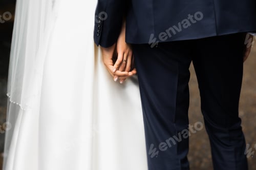 Preview: Hands of bride and groom. New young couple holding hands after their wedding
