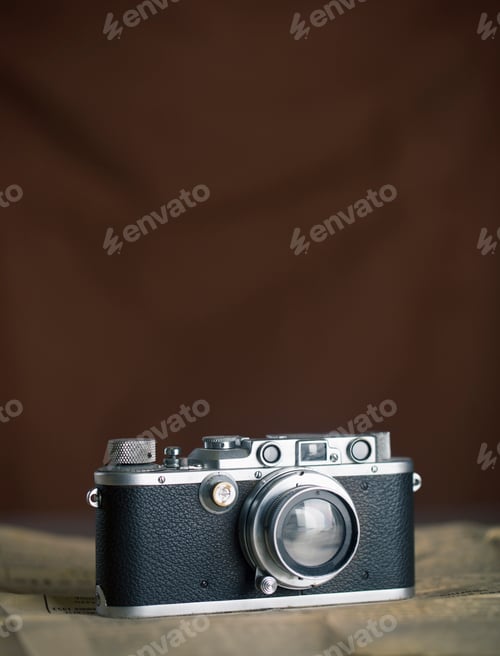 Preview: Vintage camera resting on a surface with a blurred background.