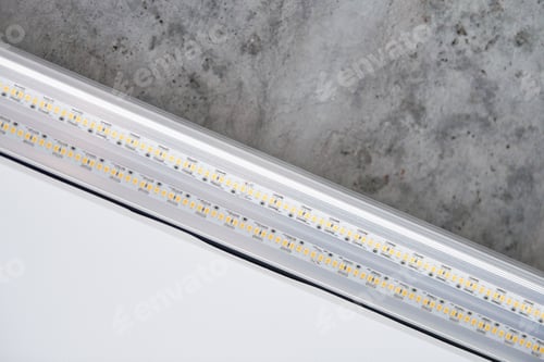 Preview: Strip LED light with aluminum profile on stretch ceiling, close up. Home renovation concept