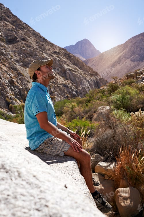 Preview: mid adult caucasian man sitting outdoors relaxed meditating with eyes closed in the Elqui Valley