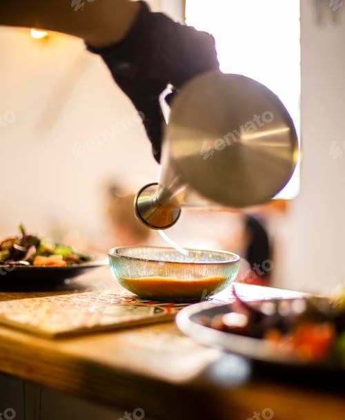 Preview: Oilcan pouring oil onto a plate in the pass of a restaurant kitchen