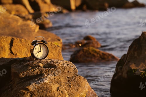 Preview: Clock Alarm Clock Stand On The Sea In The Evening At Sunset