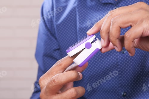 Preview: close up of man hand using pulse oximeter