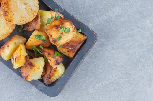 Preview: Fried fresh potatoes in black plate on grey background