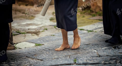 Preview: Barefoot penitent walking on cobblestones during Good Friday procession