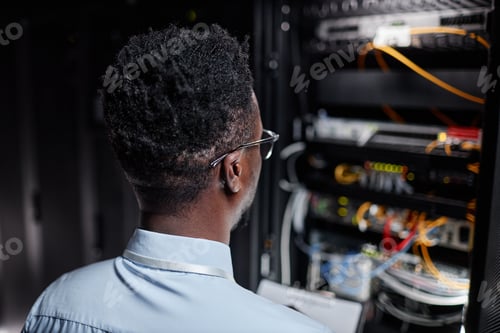 Preview: Back view network engineer working with server cabinet in data center