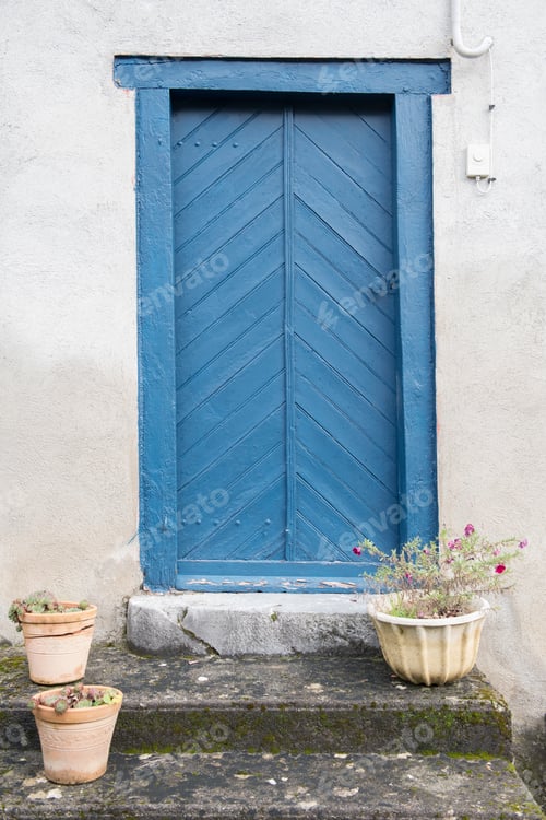 Preview: Building with blue door and flowers on steps