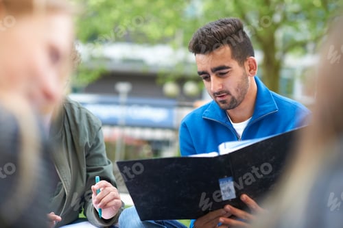 Preview: Students sitting outdoors studying