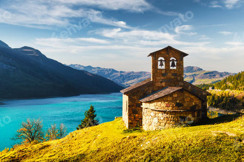 Preview: Sunny picturesque view of stone chapel on Roselend lake