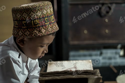 Preview: Smart school Asian boy reading an antique book at the Pedir Museum Aceh