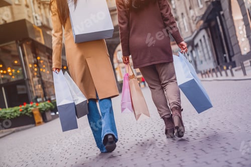 Preview: Close up of female women legs walking while buying clothes presents on black friday.