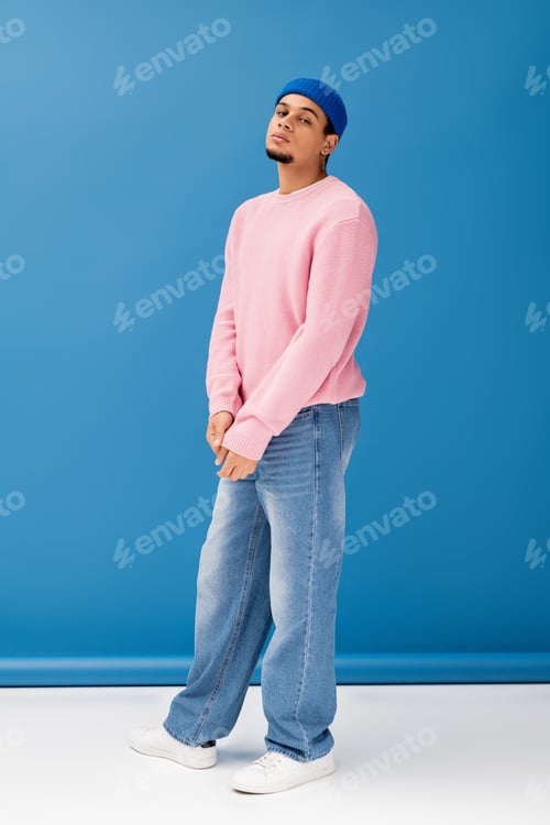 Preview: Handsome young man showcasing trendy fashion in a vibrant studio setting