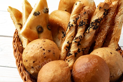 Preview: Bakery products in straw bread basket on wooden table