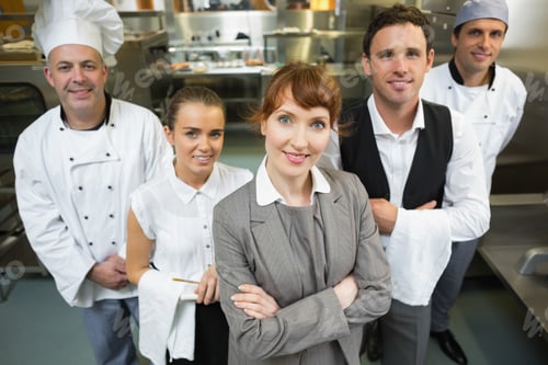 Preview: Cute Female Manager Posing With The Staff In A Modern Kitchen