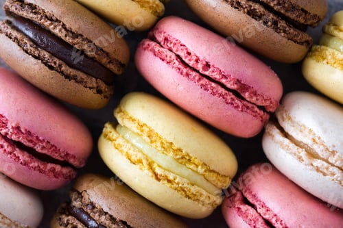 Preview: Colorful french macarons forming appealing composition on dark background