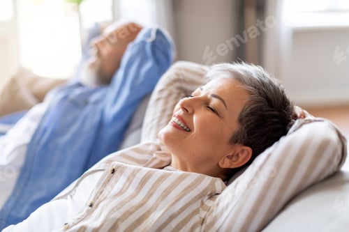 Preview: Smiling Senior Couple Resting Together On Comfortable Sofa At Home