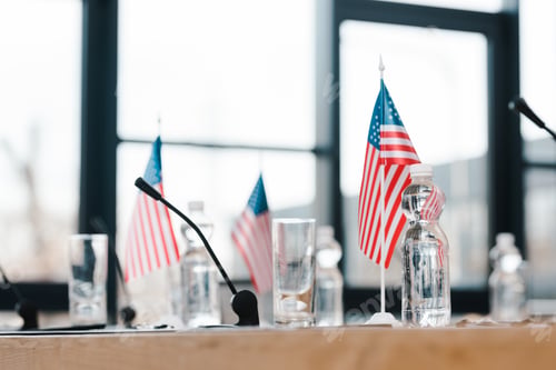 Preview: selective focus of american flags near glasses and bottles with water on table