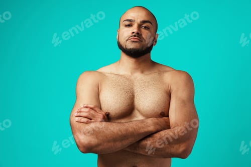 Preview: Young black man bodybuilder with naked torso standing with his arms crossed