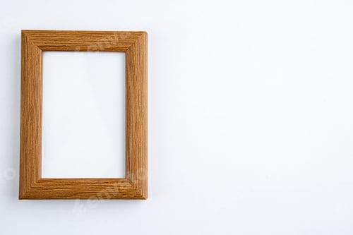 Preview: Close up view of dark brown empty picture frame on the right side on white background with free
