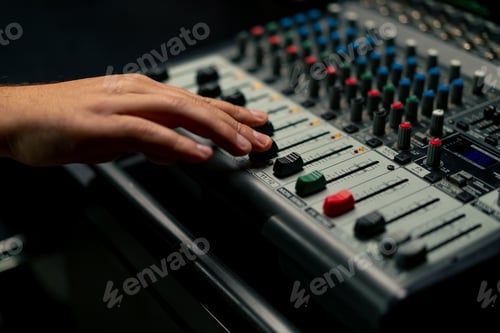 Preview: close-up hand of sound engineer switching settings on the mixing console for recording a soundtrack