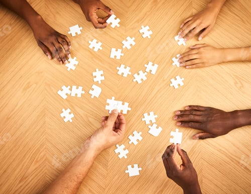Preview: Cropped shot of a group of businesspeople completing a puzzle together on a table