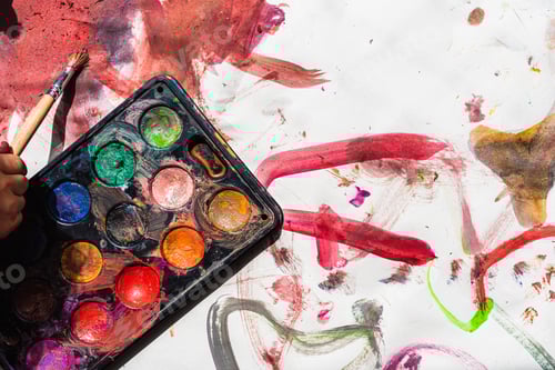 Preview: View from above of some watercolors scattered on a work table.