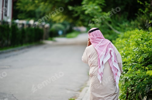 Man in Traditional Dress Walking Along Road