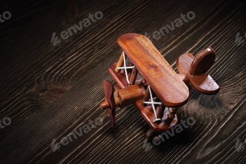 Preview: Wood toy plane on rustic wooden table.