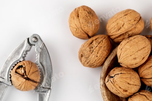 Preview: Walnuts with nutcracker on a white background